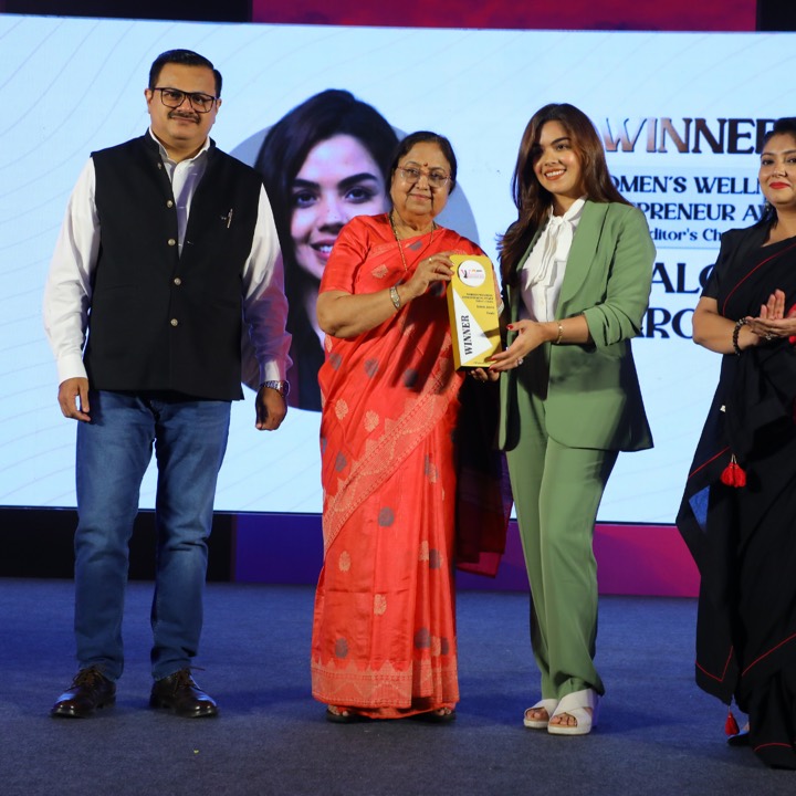 Saloni receiving the Women's Wellness Entrepreneur award on stage